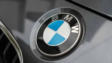 Close up of a BMW emblem on a front bumper, representing the BMW class action.