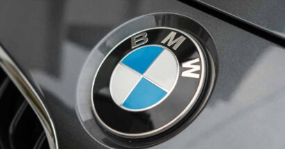 Close up of a BMW emblem on a front bumper, representing the BMW class action.