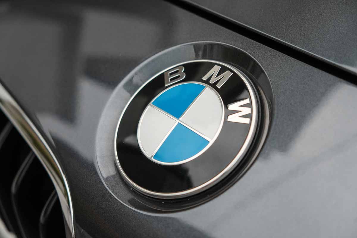 Close up of a BMW emblem on a front bumper, representing the BMW class action.