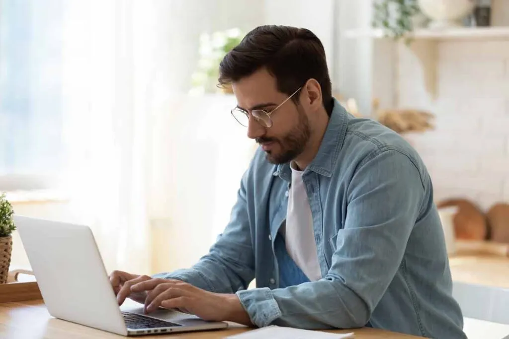 A man using a computer at home, representing the Workit Health settlement.