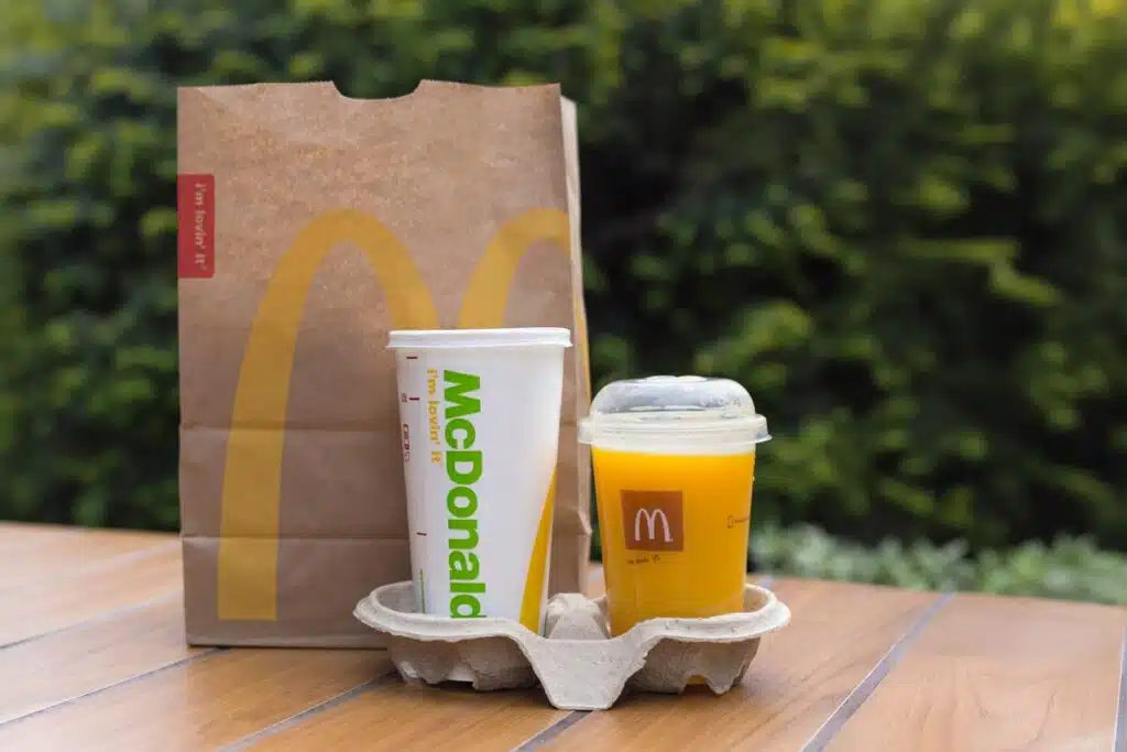 McDonald's orange juice, next to a McDonald's cup and bag, representing the McDonald's class action.