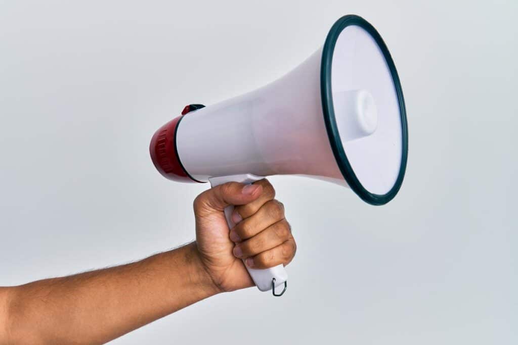 Close up of a hand holding a megaphone, representing top recalls for the week of Dec. 23.