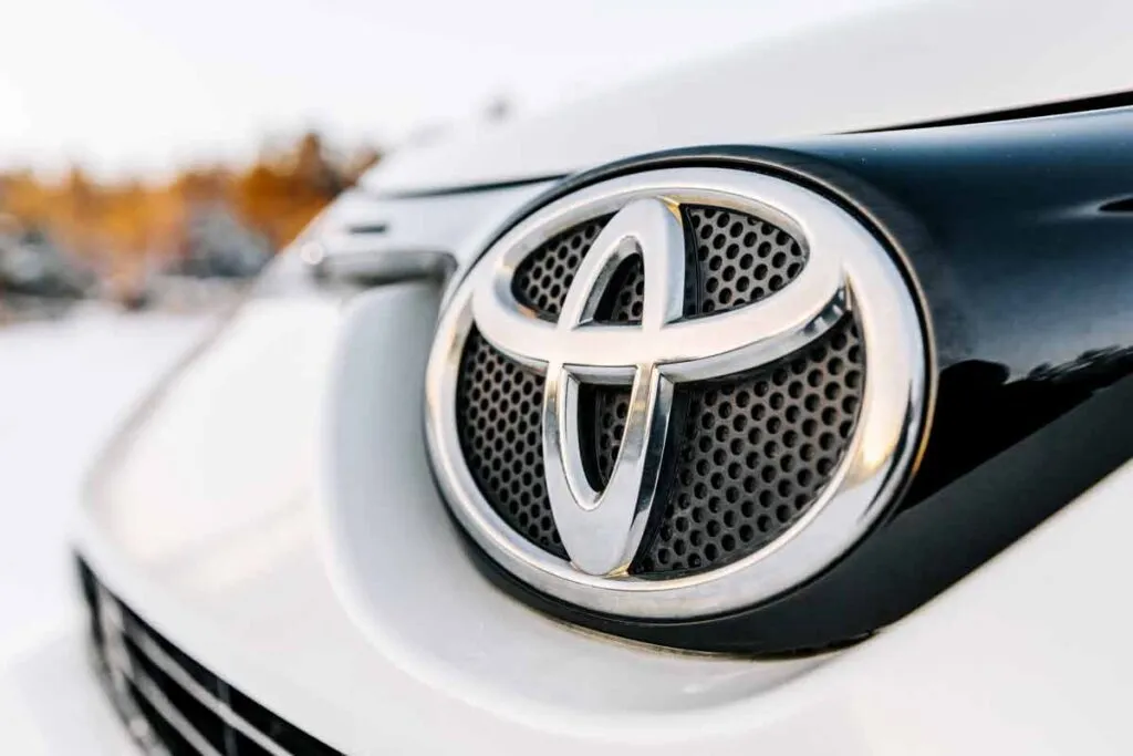 Close up of a Toyota emblem on a front bumper, representing Toyota recalls and class actions.