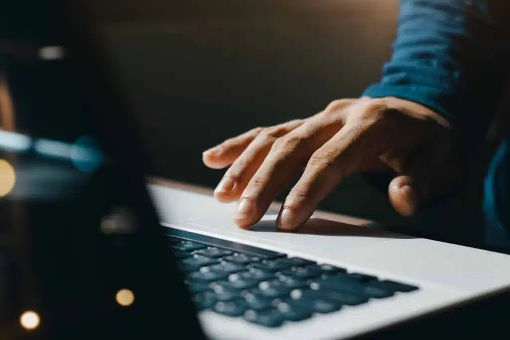 Close up of hand using a laptop, representing the Andrews McMeel Universal settlement.