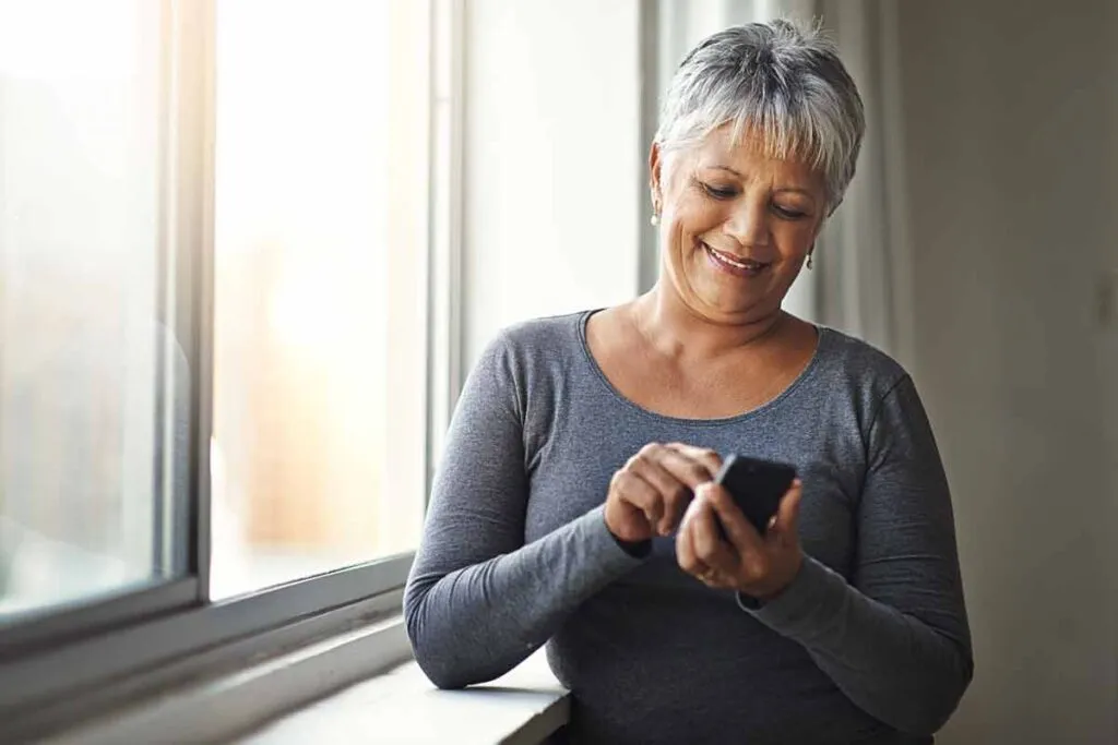 A senior woman using a smartphone, representing the Senior Dating data breach.