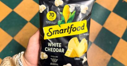 Close up of a hand holding Smartfoods white cheddar popcorn, representing the Smartfoods class action.