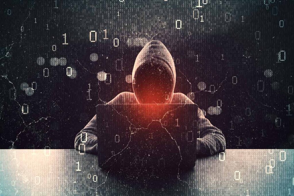 A hooded hacker using a computer, representing the Rhode Island data breach.