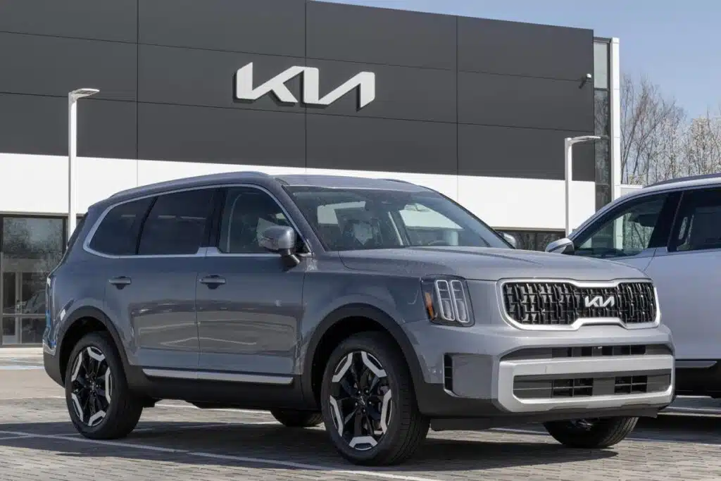 A 2024 gray Kia Telluride in front of a Kia dealership, representing the Kia class action.