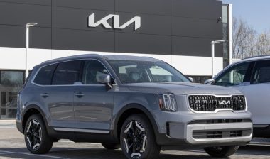 A 2024 gray Kia Telluride in front of a Kia dealership, representing the Kia class action.