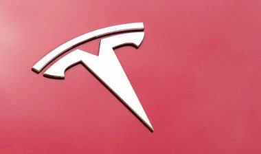 Close up of Tesla emblem on a front bumper, representing the Tesla recall.