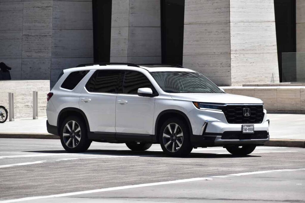 A 2024 white Honda Pilot on a roadway, representing the Honda recall.