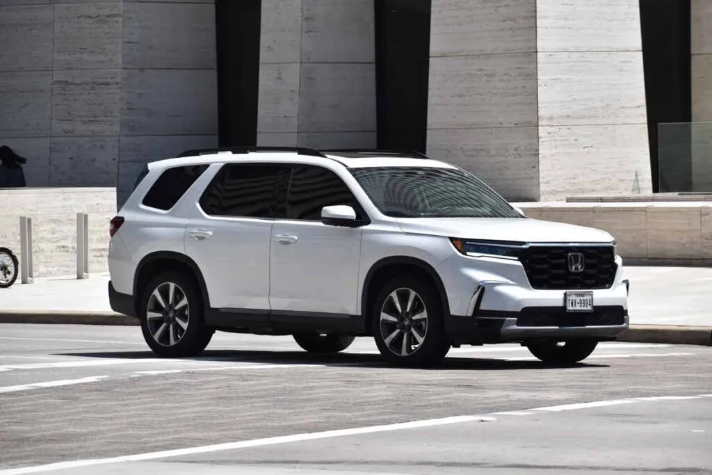 A 2024 white Honda Pilot on a roadway, representing the Honda recall.