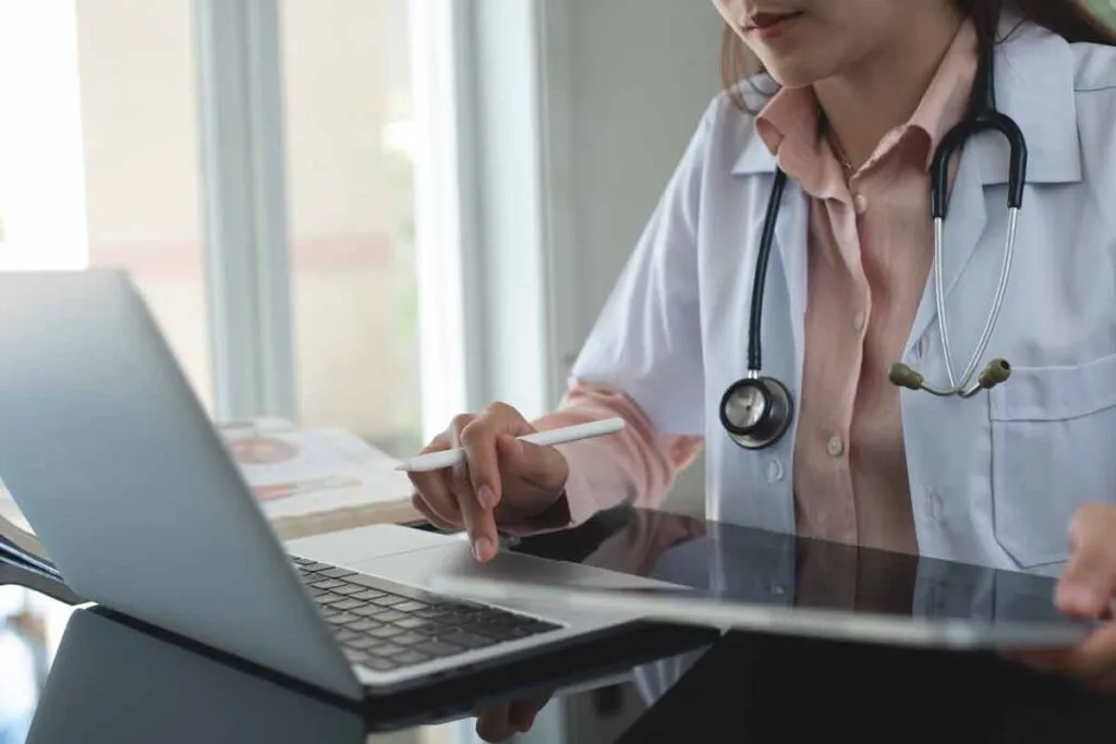 Close up of a doctor using a laptop, representing the Columbus Regional Healthcare settlement.