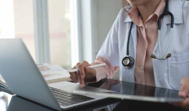 Close up of a doctor using a laptop, representing the Columbus Regional Healthcare settlement.