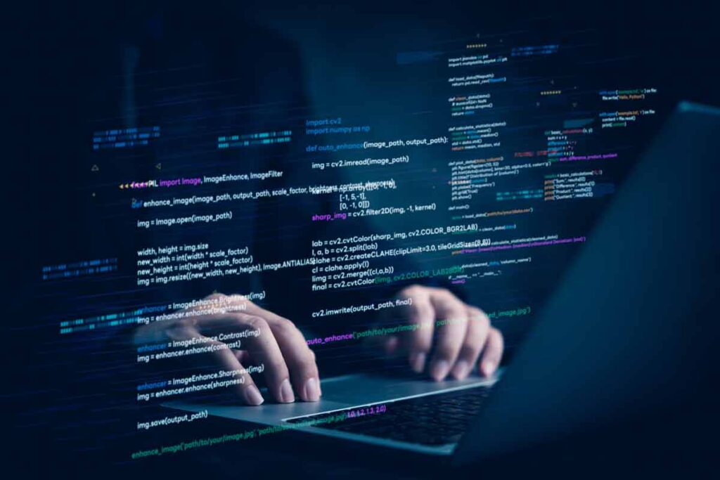 Close up of a hackers hands typing on a laptop with a code overlay, representing the PRGX Global settlement.