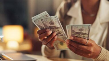 Close up of a woman's hands counting cash, representing FTC refunds.