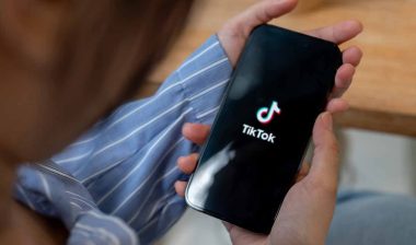 Close up of hands holding a smartphone with the TikTok logo displayed, representing the TikTok class action.