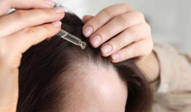 Close up of woman putting oil in her hair, representing the Mielle Organics class action.