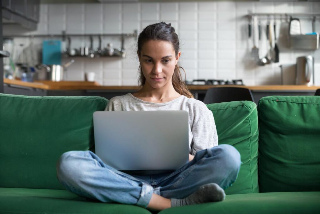 A woman using a laptop in her home, representing the RetailMeNot class action.