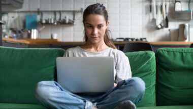 A woman using a laptop in her home, representing the RetailMeNot class action.