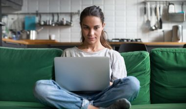 A woman using a laptop in her home, representing the RetailMeNot class action.