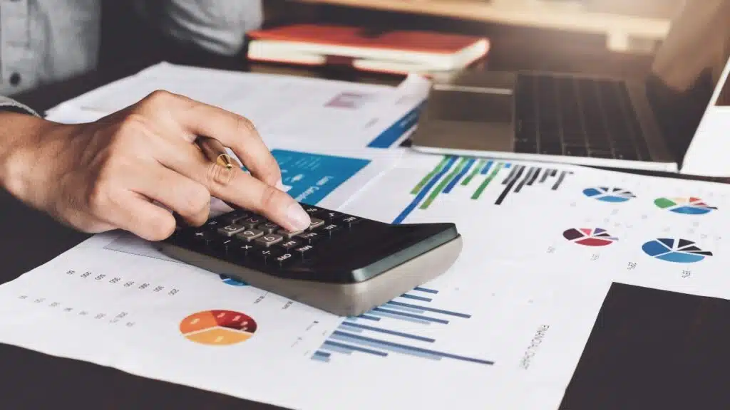 Bookkeeper accounting Concepts; Male use calculator, pen and laptop computer to monitor money saving reports budget