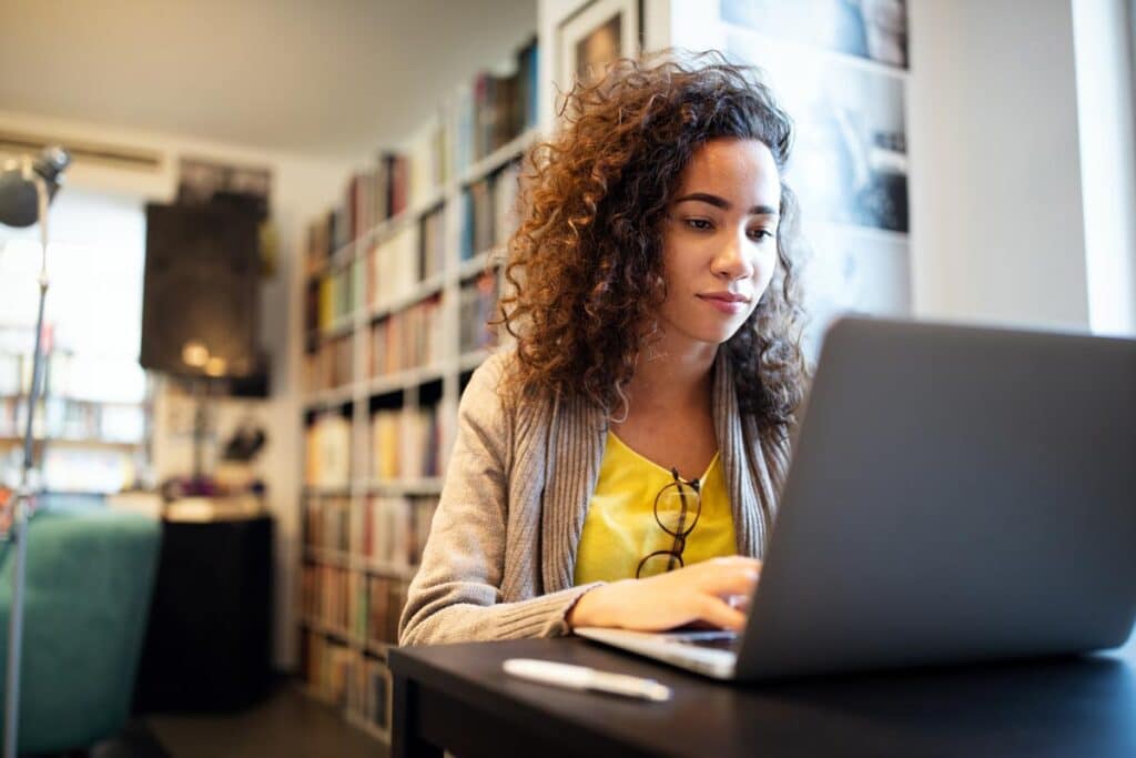 A student using a computer in the library, representing the PowerSchool class actions.
