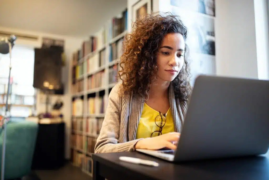 A student using a computer in the library, representing the PowerSchool class actions.