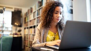 A student using a computer in the library, representing the PowerSchool class actions.
