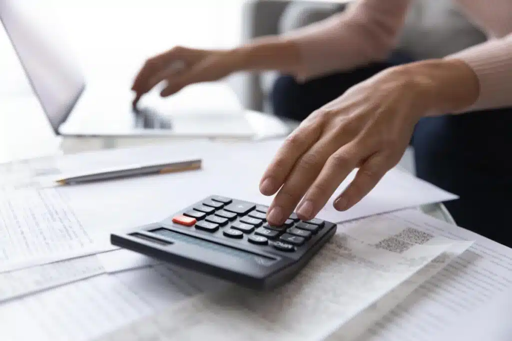 Close up of a woman's hands using a calculator, representing the Meridian Heights settlement.