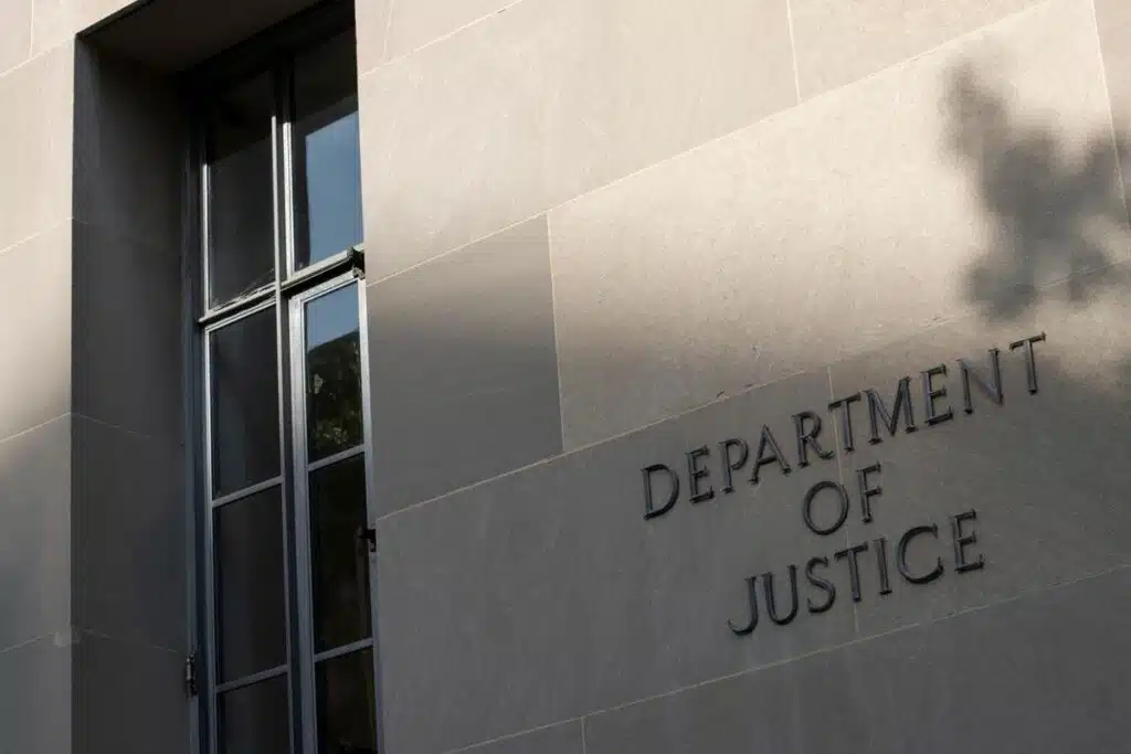 U.S. Department of Justice headquarters signage, representing the U.S. Victims of State Sponsored Terrorism Fund to victims.