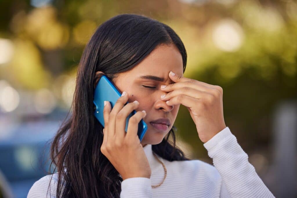 An annoyed woman on the phone, representing the Deere Credit Services settlement.