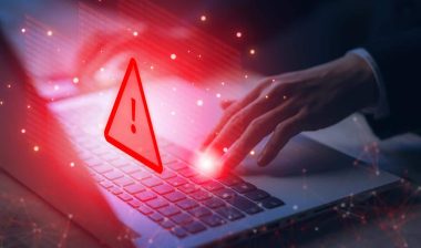 Close up of hands typing with a warning symbol overlay, representing the Norwex class action.