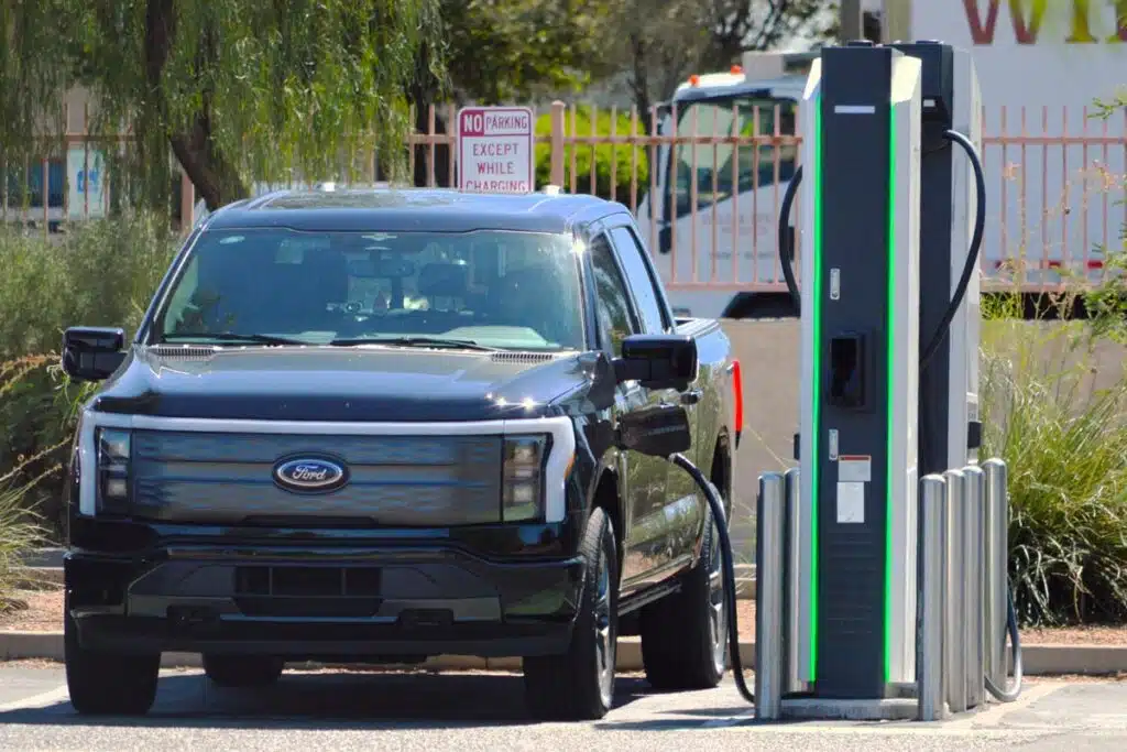 A Ford F-150 Lightning at a charging station, representing the Ford recall.