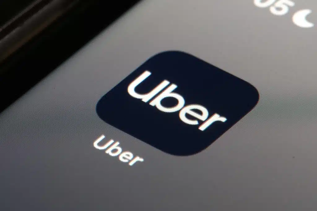 Uber app icon displayed on a smartphone screen, representing the Uber driver settlement.