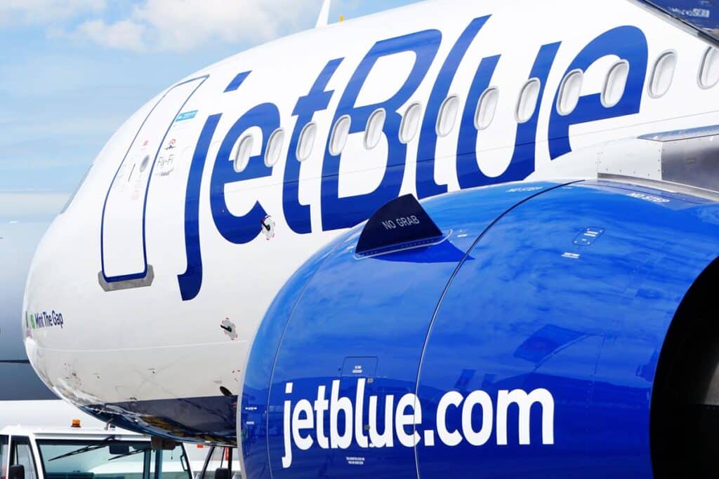 Close up of JetBlue logo on the side of a plane, representing JetBlue delayed flights.