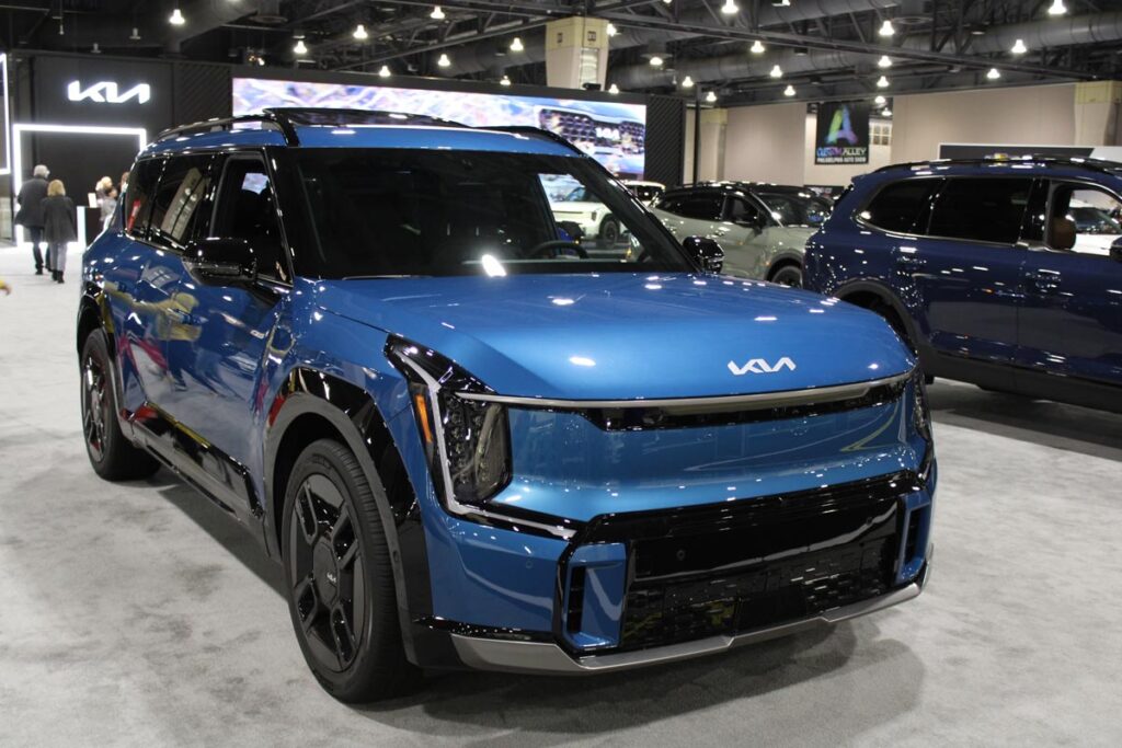 A blue Kia EV9 at a car show, representing the Kia recall.