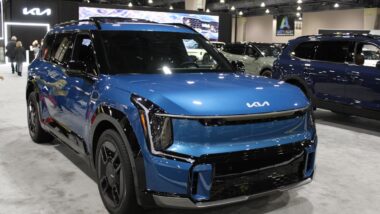 A blue Kia EV9 at a car show, representing the Kia recall.