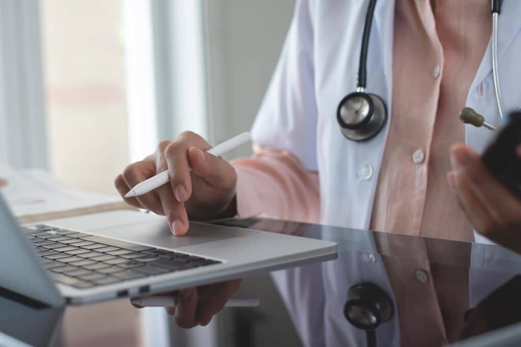 Close up of a doctor using a laptop, representing the Morrison Community Hospital settlement