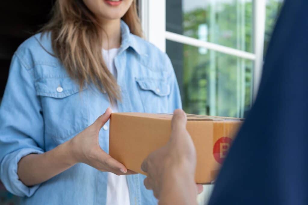 A woman receiving a meal delivery, representing the Daily Harvest settlement.