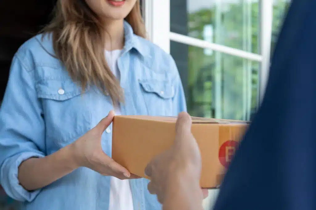 A woman receiving a meal delivery, representing the Daily Harvest settlement.
