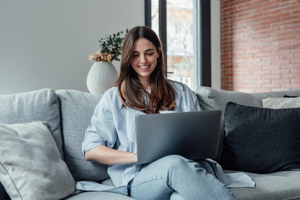 A young woman using a laptop, representing the Audienceview Ticketing settlement.