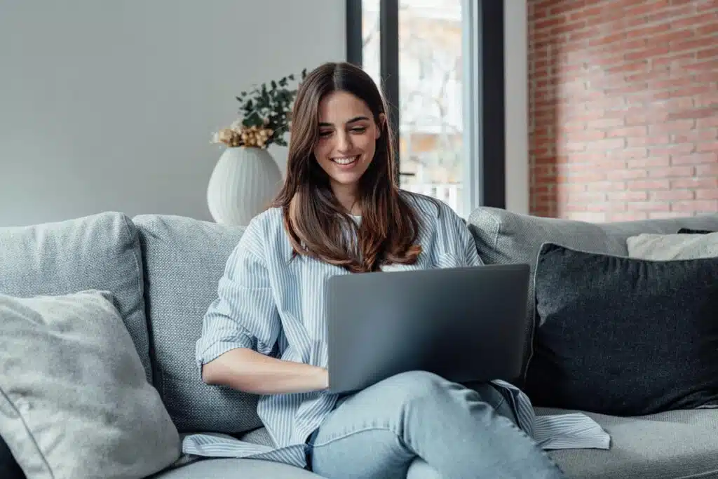 A young woman using a laptop, representing the Audienceview Ticketing settlement.