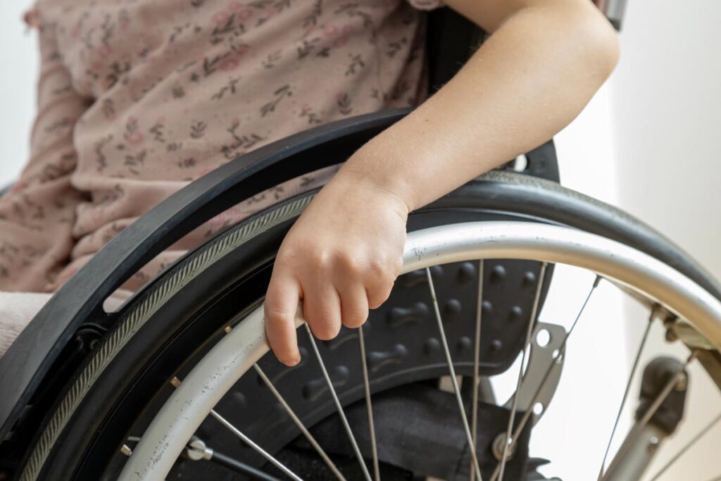 Close up of a hand on a wheelchair, representing the wheelchair power assist device recall.