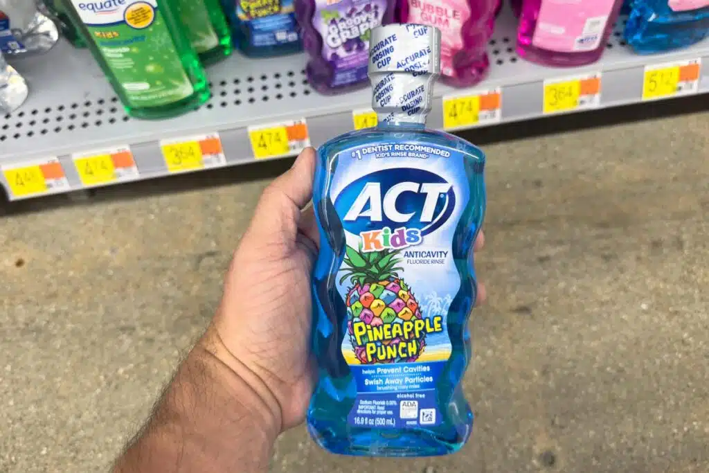 Hand holding ACT kids mouth rinse, representing the ACT mouthwash class action.