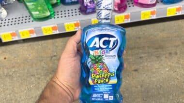 Hand holding ACT kids mouth rinse, representing the ACT mouthwash class action.