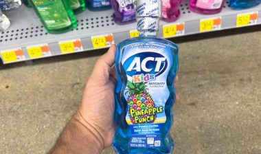 Hand holding ACT kids mouth rinse, representing the ACT mouthwash class action.