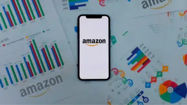 Iphone 11 pro with the Amazon logo. on top of charts