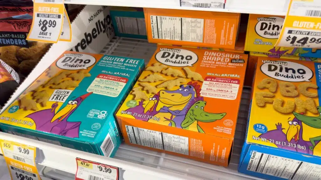 A view of several packages of Yummy Dino Buddies, on display at a grocery store.