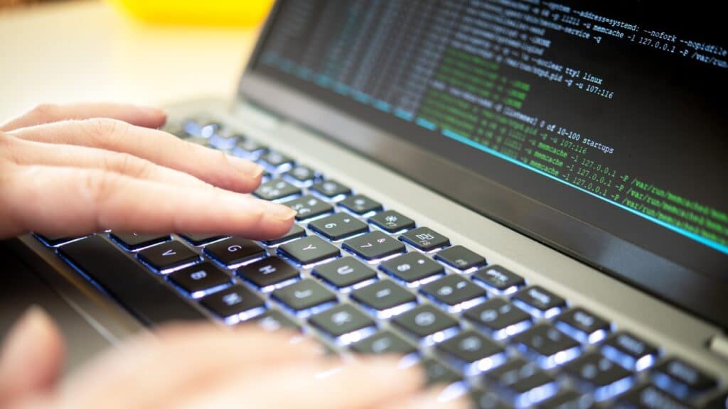 Hacker code on a laptop, highlighting issues of cybersecurity, privacy threats, data leaks and server processes.